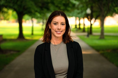 Woman smiling at camera with trees behind her