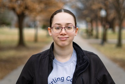 Woman smiling at camera with trees behind her