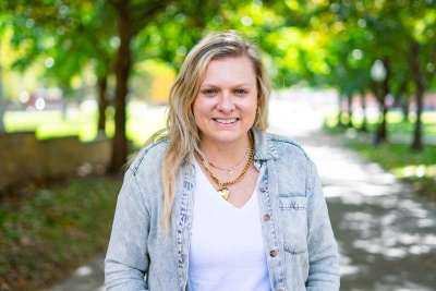 Woman smiling at camera with trees behind her
