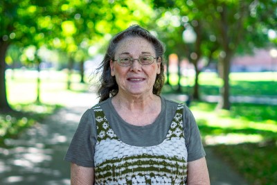 Woman smiling at camera with trees behind her