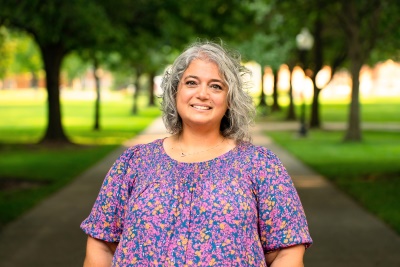 Woman smiling at camera with trees behind her Woman smiling at camera with trees behind her