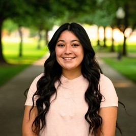 Woman smiling at camera with trees behind her