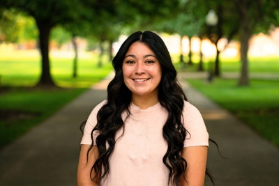 Woman smiling at camera with trees behind her Woman smiling at camera with trees behind her