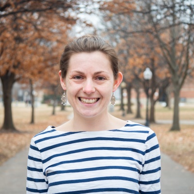 Woman smiling at camera with trees behind her