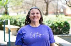 Woman smiling at camera with trees behind her