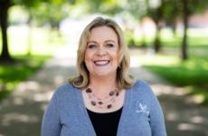 Woman smiling at camera with trees behind her