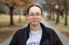 Woman smiling at camera with trees behind her