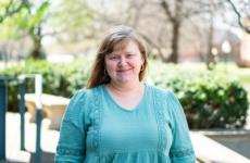 Woman smiling at camera with trees behind her