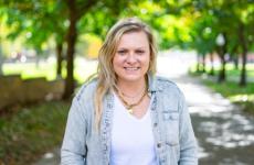 Woman smiling at camera with trees behind her