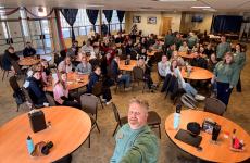 Man takes selfie of the whole room of students and teachers sitting in chairs