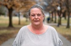 Woman smiling at camera with trees behind her