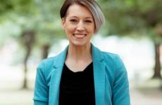 Woman smiling at camera with trees behind her