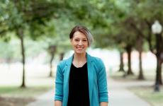 Woman smiling at camera with trees behind her