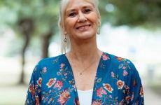 Woman smiling at camera with trees behind her