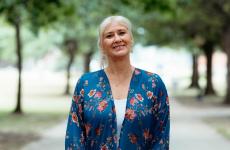 Woman smiling at camera with trees behind her