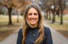 Woman smiling at camera with trees behind her