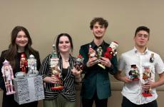Four students holding Christmas nutcrackers