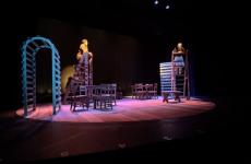 Two people on ladders on a theatre stage