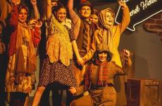 theatre students posing for the finale of a song with their hands in the air