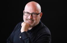 Man dressed nicely wearing glasses smiling at the camera