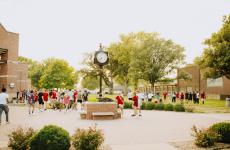 students outside playing games with a clock tower in the middle