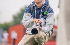 Man kneeling on field holding a camera Man kneeling on field holding a camera