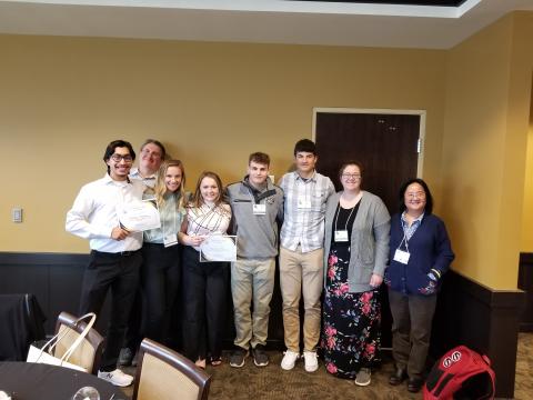 Students and Faculty pose for a photo at a conference