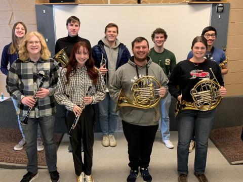 9 band students standing in two rows smiling for picture