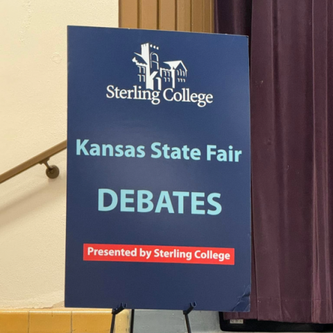 Blue sign that says Kansas State Fair Debates presented by Sterling College