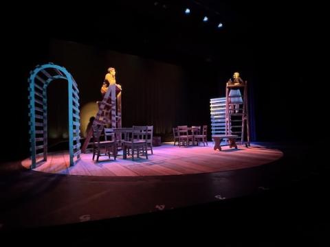 Two people on ladders on a theatre stage