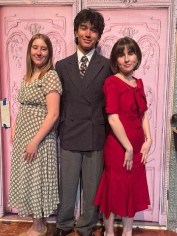 three people dressed nicely and posing for the camera