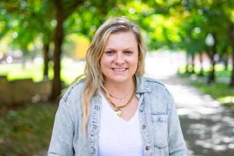 Woman smiling at camera with trees behind her