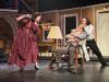 3 student actors acting out a scene on stage